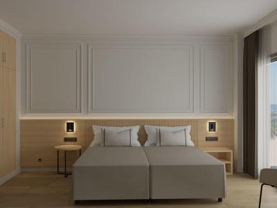 Modern hotel room with double bed, nightstands, and balcony overlooking the sea.