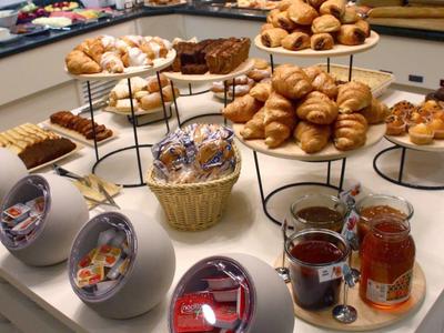 Varied breakfast buffet with croissants, jams, and spreads in a hotel.