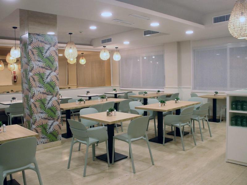 Bright dining area with modern tables and chairs and decorative lighting fixtures.