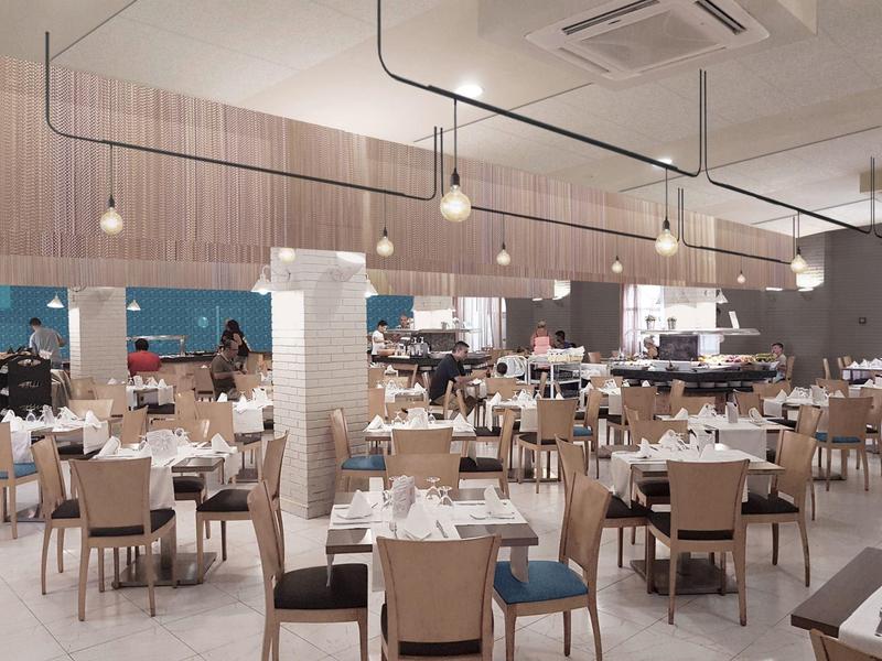 Ampia sala da pranzo moderna con luci sospese e tavoli e sedie ordinatamente disposti.