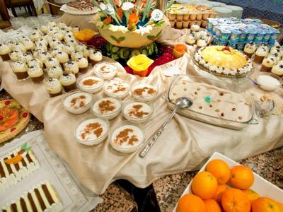 Buffet varié avec desserts, fruits et autres plats sur une table dressée.