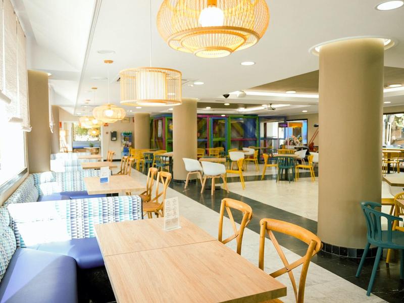 Salle à manger moderne et lumineuse avec différents espaces assis et grandes fenêtres.