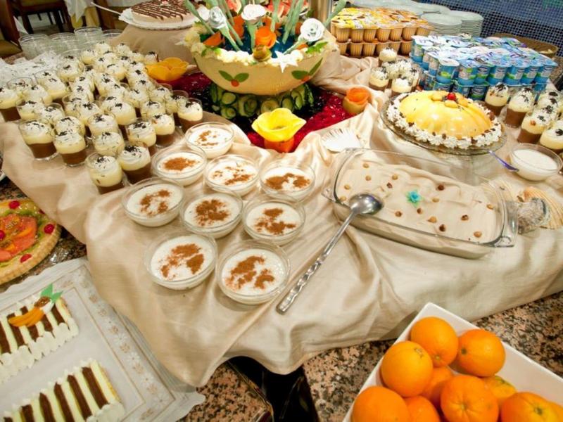 Buffet varié avec desserts, fruits et autres plats sur une table dressée.