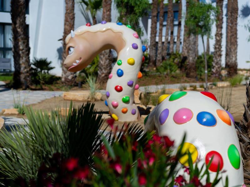 Kolorowa rzeźba żyrafy w ogrodzie przy hotelu.