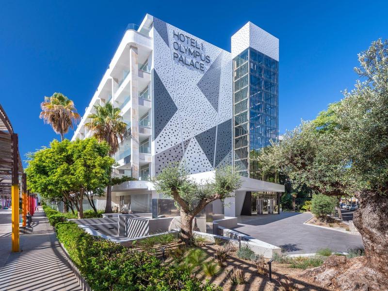 Edificio de hotel moderno con patrón geométrico y cielo azul de fondo.