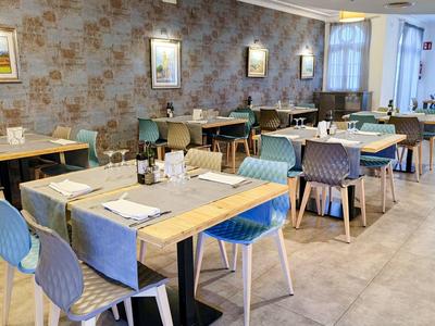 Moderní jídelna s stolem, židlemi a decentně vyzdobenými stěnami.