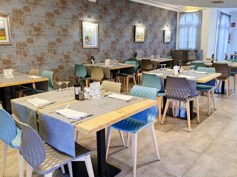 Moderní jídelna s stolem, židlemi a decentně vyzdobenými stěnami.