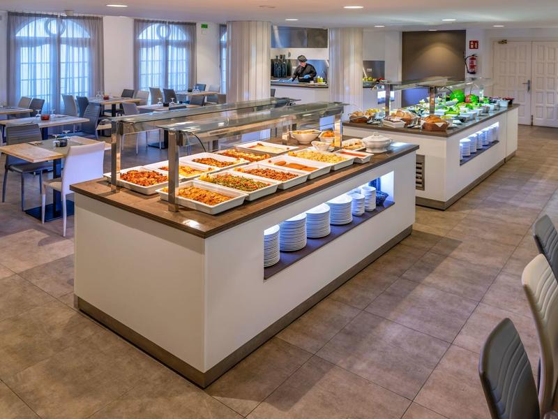 Bufetová oblast s teplými jídly a posezením v světlé restauraci.