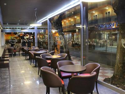 Caffè moderno con tavoli e sedie lungo grandi finestre che si affacciano sulla strada