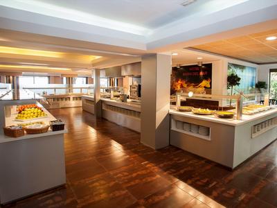 Area buffet in un hotel moderno con vari piatti e pavimento in legno.