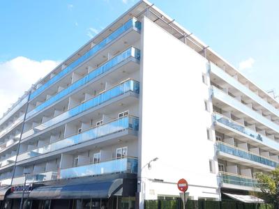 Edificio di un hotel moderno su più piani con balconi in vetro sotto un cielo sereno.