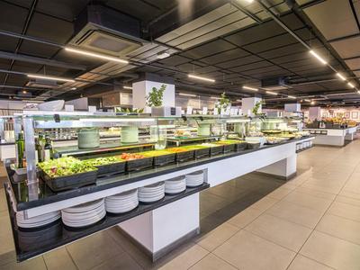 Buffet con vari cibi in una sala da pranzo moderna e spaziosa.