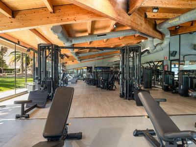 Palestra moderna con soffitto a travi in legno e vari attrezzi per esercizi