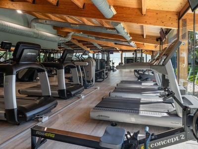 Palestra luminosa con tapis roulant moderni e travi in legno sul soffitto