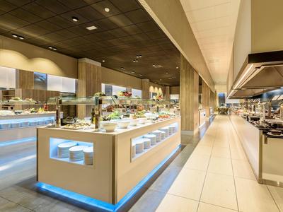 Modernes Buffet mit vielfältigen Speisen in hellem Raum und elegantem Design, ideal für Hotelgäste.