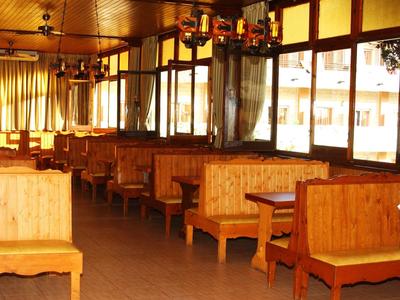 Helles, gemütliches Restaurant mit Holzmöbeln und großen Fenstern, ideal für einen Hotelaufenthalt.