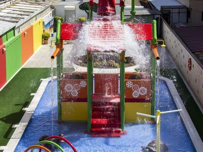 Kinderwasserpark mit bunten Rutschen, Planschbecken und Wasserspielen unter freiem Himmel.