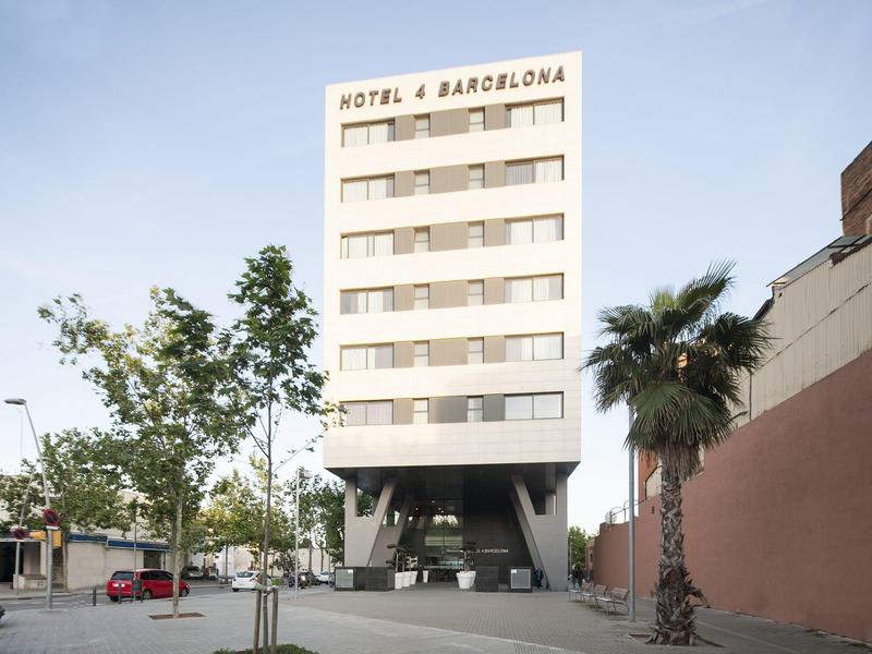 Vysoká moderní budova Hotel Barcelona s bílou fasádou a palmami u vstupu.