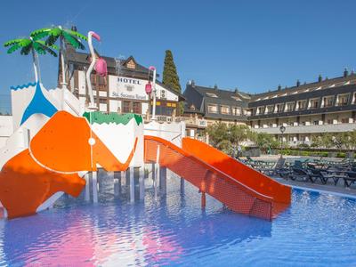 Tobogán de agua colorido en la piscina de un hotel bajo un cielo azul