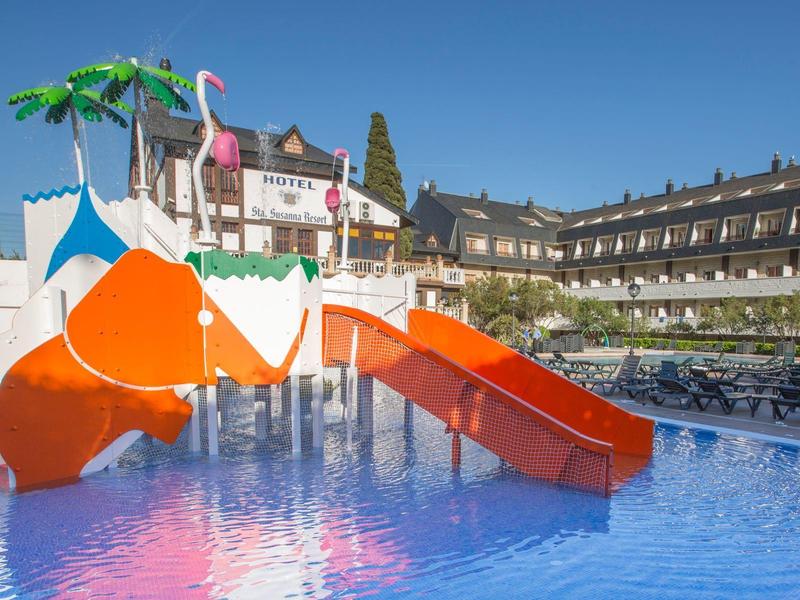 Wasserrutsche mit orangefarbenen Rutschen und künstlerischen Flamingo- und Palmenmotiven im Schwimmbad.