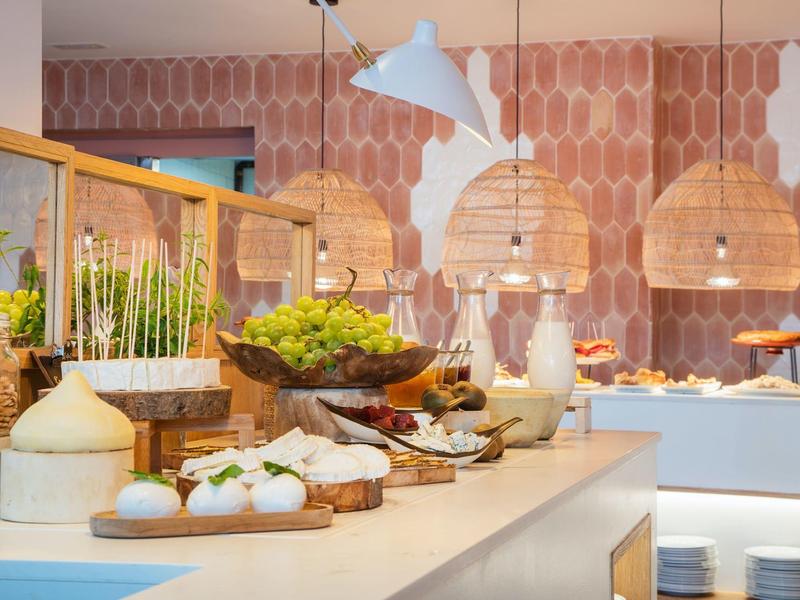 Buffet avec différents pains, garnitures et décorations colorées dans une salle moderne.