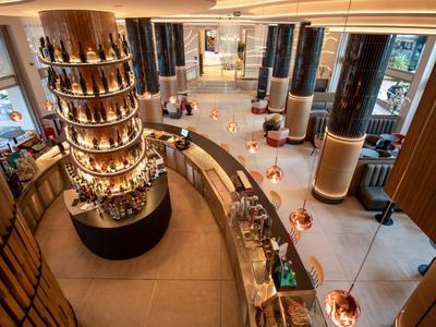 Moderne Hotellobby mit rundem Empfangstresen und dekorativen Säulen in hellem Design.