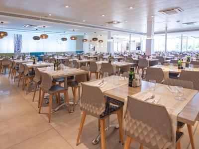 Helles, modernes Restaurant mit vielen Tischen und Stühlen, bereit für Gäste.