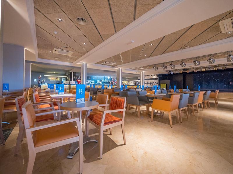 Großer, moderner Speisesaal mit bunten Stühlen und gedeckten Tischen in einem Hotel.