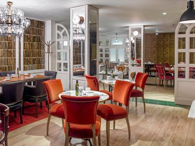 Ristorante elegante dell'hotel con sedie colorate e lampadario in un'atmosfera calda.