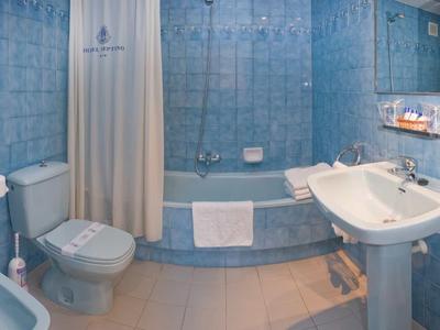 Lichte badkamer met blauwe tegels, badkuip, handdoeken en sanitaire voorzieningen