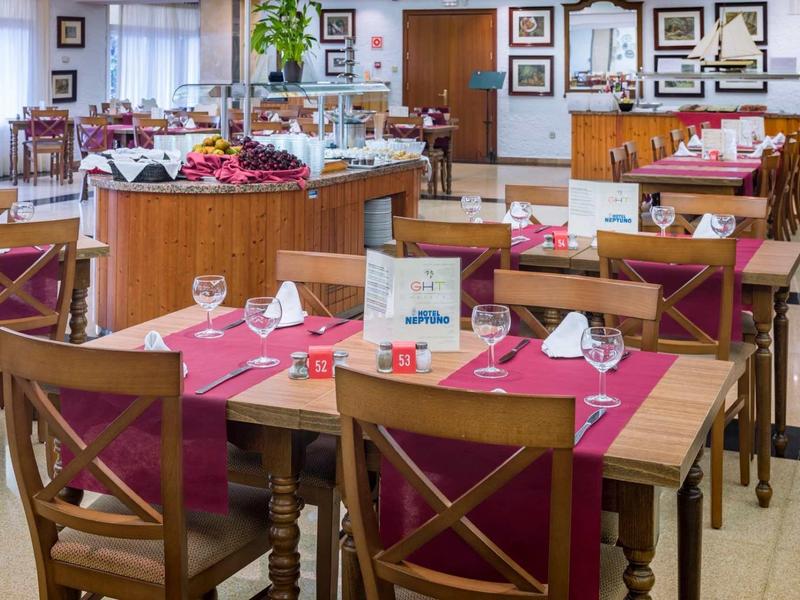 Licht ontbijtzaal met meerdere gedekte houten tafels en rode placemats.