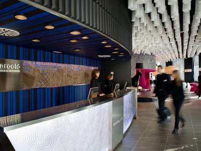 Moderne hotelreceptie met stijlvolle verlichting en personeel bij de balie.