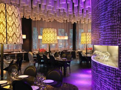 Elegant restaurant met decoratieve lampen en gedekte tafels in warm licht.