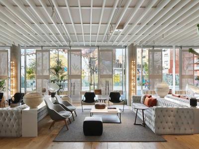 Großer moderner Hotel-Loungebereich mit bequemen Sofas, Pflanzen und viel natürlichem Licht.