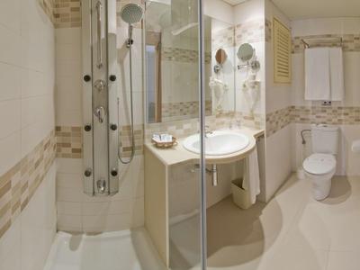 Helle, moderne Badezimmereinrichtung mit Duschkabine, Waschbecken und WC.