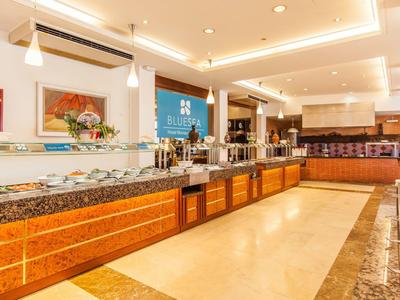 Jasno oświetlony bufet z różnorodnymi potrawami i nowoczesnym designem.