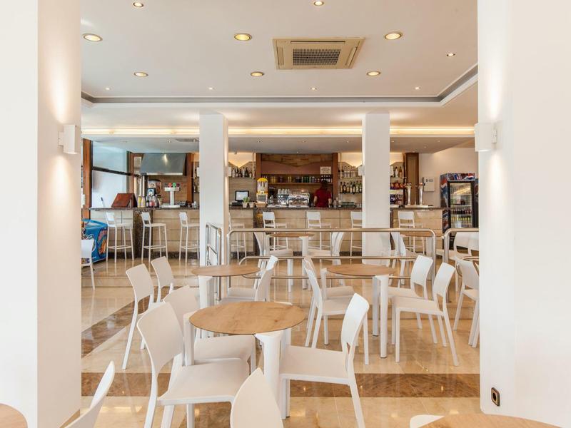 Jasna, nowoczesna sala śniadaniowa z białymi krzesłami i stołami w hotelu.