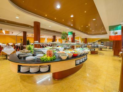 Buffetgedeelte van een restaurant met diverse fruit- en saladeopties in een elegante omgeving.