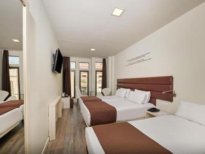 Camera d'hotel con due letti, TV a schermo piatto e finestra con vista esterna.