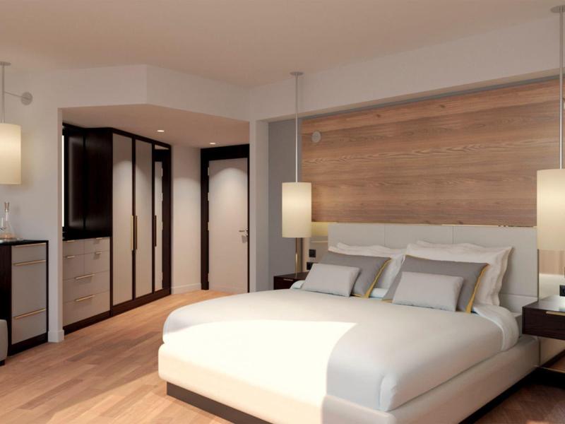 Modern hotel room with large bed, wooden floor, and stylish lighting.