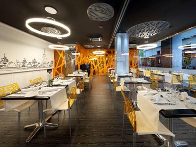 Modernes Restaurant mit gelben und weißen Stühlen und dekorativer Beleuchtung.