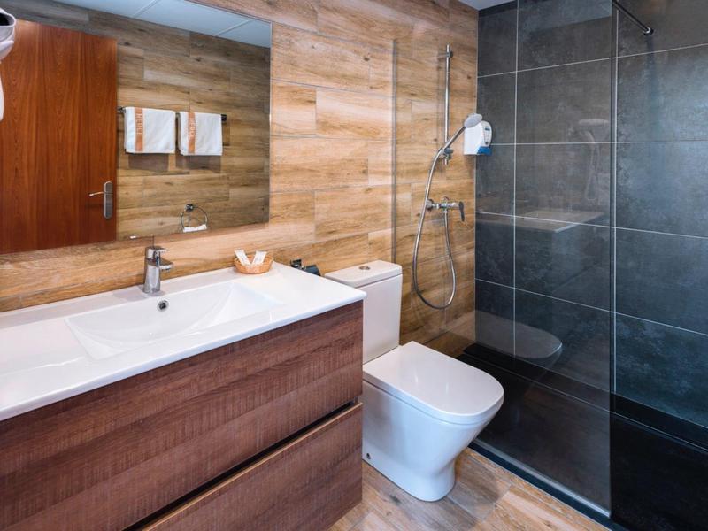 Bagno moderno con lavabo, WC e doccia con porta in vetro.