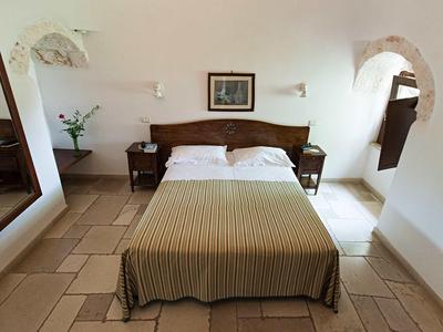 Schlicht eingerichtetes Schlafzimmer mit Doppelbett, zwei Nachttischen und Bild an der Wand.