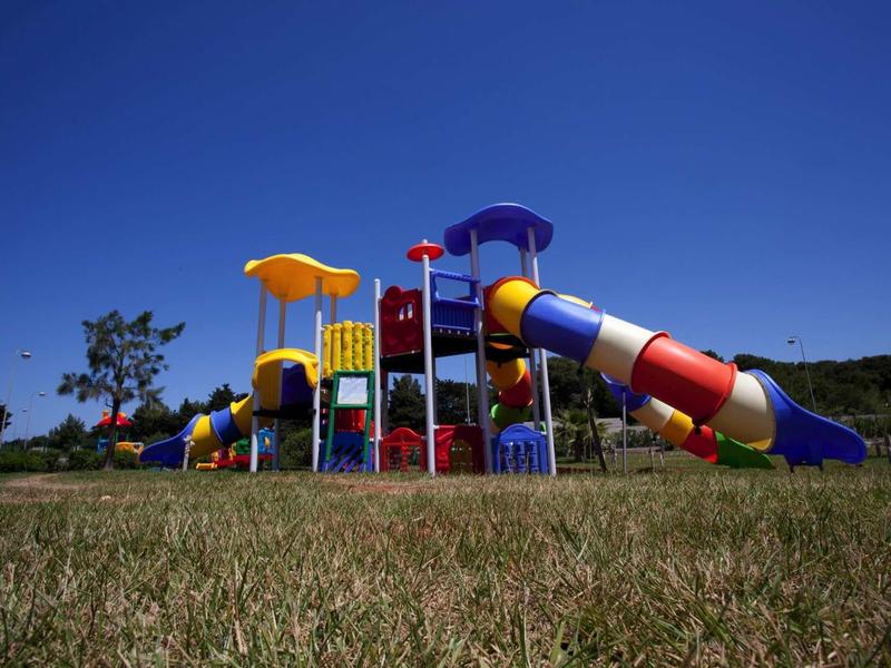 Colorful playground with slides and climbing structures under clear blue sky.