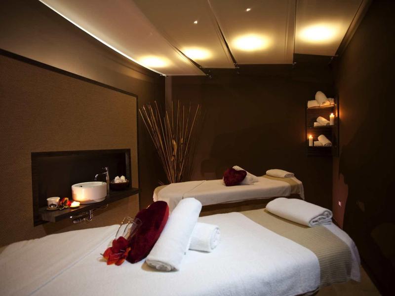 Relaxing spa room with two massage tables and warm, soft lighting.