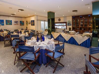 Elegantes Restaurant mit blau gedeckten Tischen und Holzmöbeln in einem Hotel.