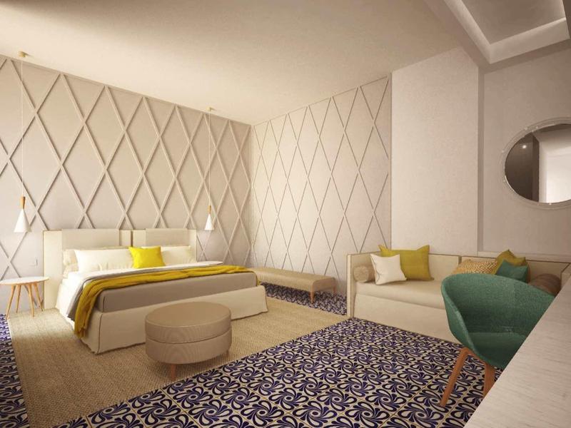 Helles Schlafzimmer mit Doppelbett, gelben Akzenten, beigem Sofa, blauem Sessel und gemustertem Teppich.