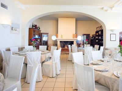 Restaurant élégant avec des housses de chaise blanches et des tables dressées à côté d'une cheminée.