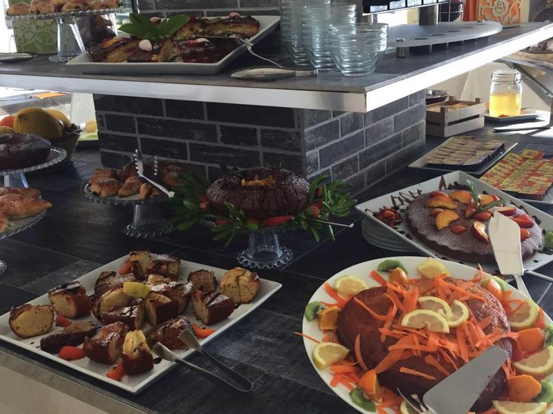 Buffet with various meat and vegetable dishes on a dark counter.