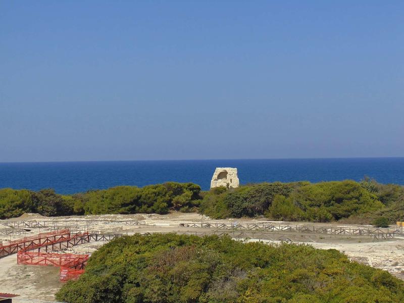 Ruins and an ancient watchtower ruin by the Mediterranean under a clear sky